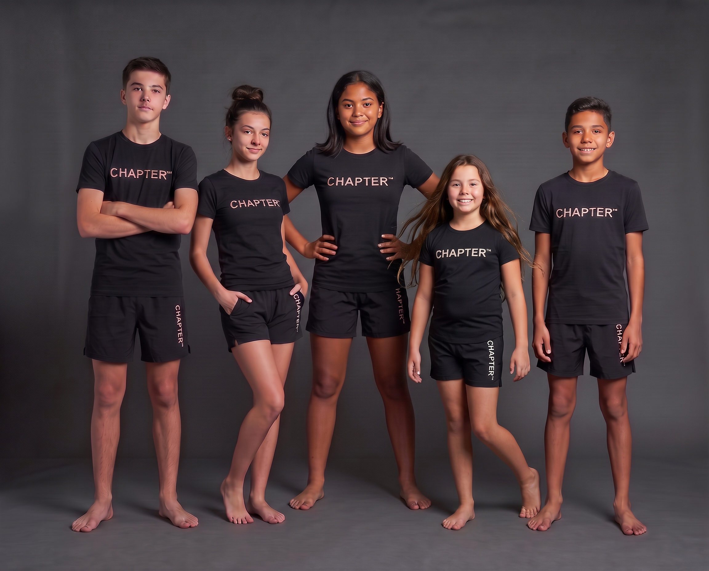 Five young people aged 10–15, including a girl in a confident hands-on-hips pose, wearing the black CHAPTER™ T-shirt and shorts