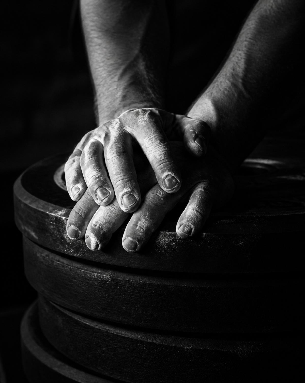 Chalked hands resting on weight plates